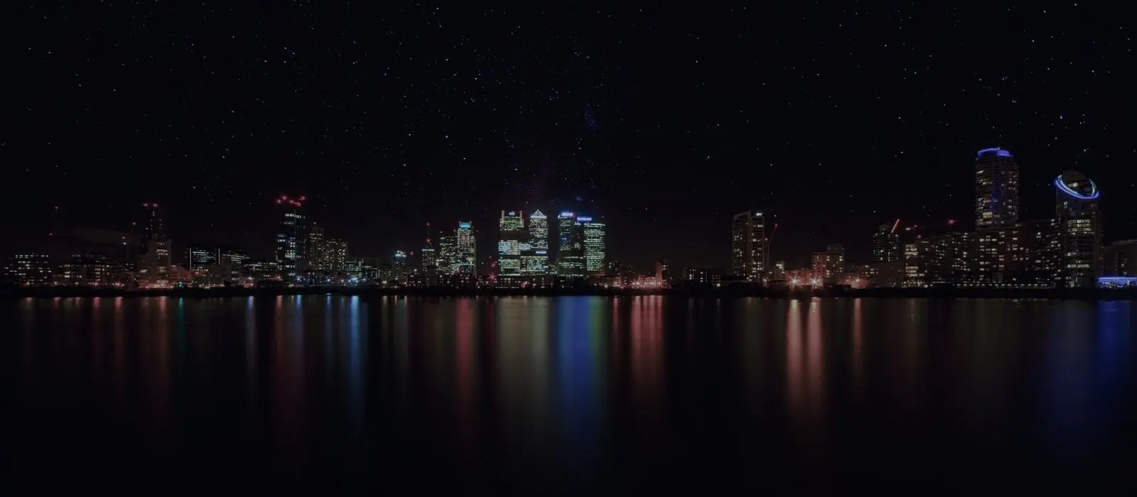 Vista nocturna de una ciudad con cerros al fondo